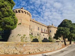 a large castle with a stone wall and trees at La Casa di MaGioLò in Serracapriola