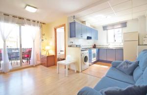 een woonkamer met een blauwe bank en een keuken bij TODO INCLUIDO - Wifi,playa,piscina 24h,garaje,terraza y Mercadona -MUY CÓMODO in Canet de Berenguer