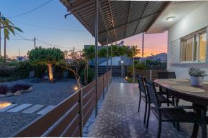a patio with a wooden fence and tables and chairs at Beachside Apartment-2 in Afantou