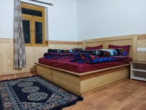 a bed with pillows on it in a room at FE Homestay Kaza By Soma Stays in Kaza