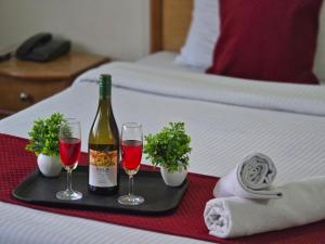 a tray with a bottle of wine and two glasses at Hotel City Gold in Dharmsāla