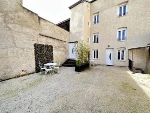 a courtyard with a table and chairs next to a building at La tour des cépages 4 personnes au cœur des vignes in Avize