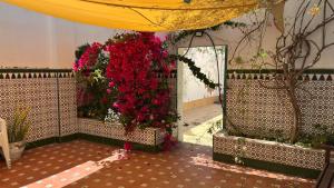 a room with a bunch of red flowers at Patios de la Carmela in Isla Cristina