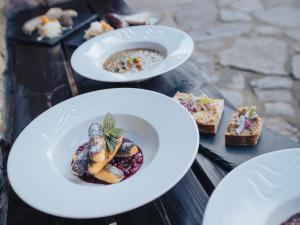 three plates of food on a wooden table at Mlýn Davídkov in Hryzely