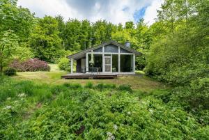 a tiny house in the middle of a garden at 2 Personen mit Sauna F0H5 in Ruhla +9 photos