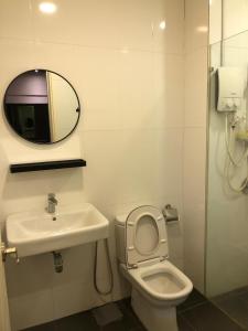 a bathroom with a sink and a toilet and a mirror at Cozy Stay in KLCC吉隆玻 in Kuala Lumpur +3 photos
