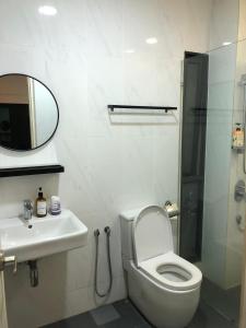 a bathroom with a toilet and a sink and a mirror at Cozy Stay in KLCC吉隆玻 in Kuala Lumpur