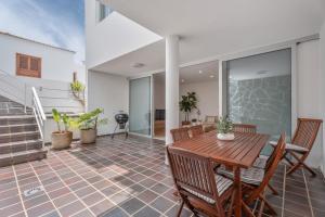 eine Terrasse mit einem Holztisch und Stühlen in der Unterkunft La Casa de Los Gigantes in Acantilado de los Gigantes