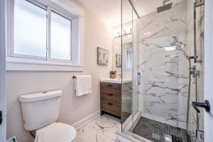 a bathroom with a toilet and a glass shower at Guest Favorite Luxury 3BR Getaway 5 Min to Lake Big Yard Fun in Burlington +56 photos
