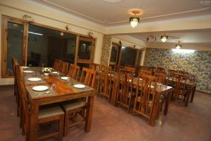 Un comedor con una gran mesa y sillas de madera. en The Radiance - kufri, en Chail