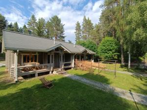 a log cabin with a yard and a fence at Kolilla oy, Purnutar B in Kolinkylä