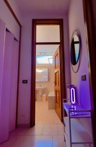 un bagno viola con lavandino e specchio di Casa Löa a Loano