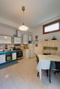 una grande cucina con un tavolo e una cucina con elettrodomestici bianchi di Casa Löa a Loano