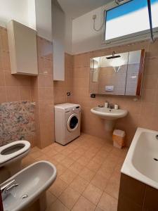 un bagno con lavatrice e lavandino di Casa Löa a Loano