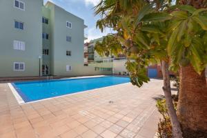 a swimming pool in front of a building at Apartamento Gabriela in Candelaria