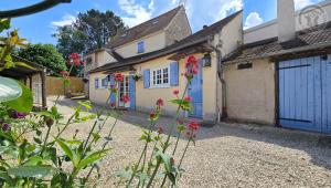 a house with a blue door and flowers in front at Maison authentique du Vexin in Théméricourt +14 photos