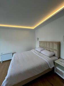 a bedroom with a large bed with a white bedspread at Apartman Runway Rest in Surčin +6 photos