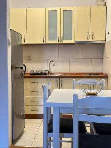 a kitchen with a blue table and a refrigerator at Apartman sa pogledom na more Budva in Budva