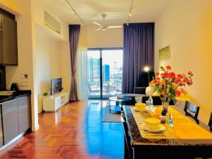 a living room with a table with flowers on it at Luxury Suites At The Mews KLCC in Kuala Lumpur