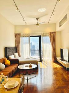 a living room with a couch and a tv at Luxury Suites At The Mews KLCC in Kuala Lumpur