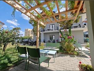 a patio with a table and chairs under a pergola at Vila Lazri in Shëngjin