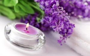a candle sitting next to a bunch of purple flowers at Apartments in Bern - Breitenrainplatz in Bern