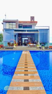 a house with a swimming pool in front of a house at De Pointé Resort & Resto in Campaka