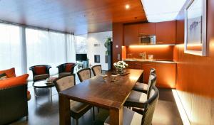 Una cocina y un comedor con mesa y sillas de madera. en Ferienhaus "Am Kühl", en Poppenhausen