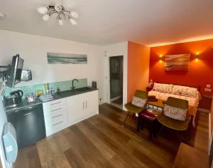 a kitchen and a bedroom with a bed and a table at The Burrows in Marytavy