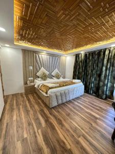 a bedroom with a large bed with a wooden ceiling at Winterfell the Stay Cottage Pahalgam in Pahalgām