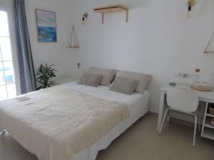 a white bedroom with a bed and a desk at Casa Julia Relax en Menorca in Cala Llonga +11 photos