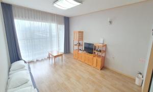 uma sala de estar com um sofá e uma televisão em Busan Metropolitan City Corporation's Arpina em Busan