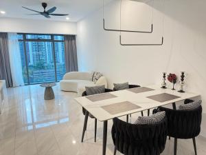 a white living room with a table and chairs at Eaton Residences KLCC By ARMAN in Kuala Lumpur