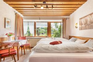 a bedroom with a large white bed and a table at Landhaus Pichler mit Sauna in Ruhpolding