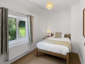 una camera da letto con un letto e una finestra di Clicket Water a Timberscombe