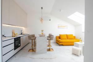 a kitchen and living room with a yellow couch at Luxury apartment Gold in Sinj