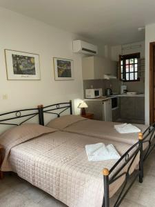 a bedroom with a large bed and a kitchen at Vasilikos Apartments in Paralia Agias Foteinis +97 photos