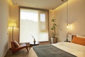 a bedroom with a bed and a large window at Come to Xipuman B&B in Baishi