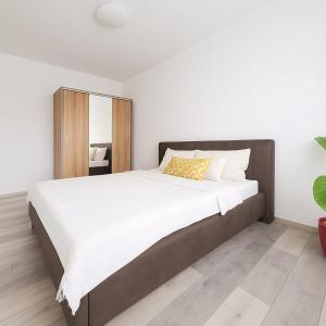 a bedroom with a large bed with white sheets at Casiana Apartments in Timişoara