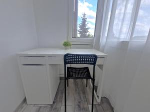 a desk with a chair in a room with a window at Casiana Apartments in Timişoara +1 photo