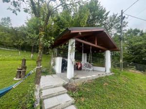 a small house with a porch and a bench at Căsuța bunicii in Vişeu de Sus