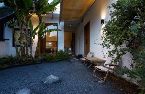 a patio with a wooden table and chairs and plants at Come to Xipuman B&B in Baishi