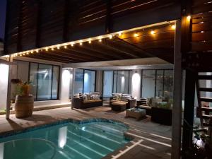 a house with a swimming pool and a patio at Hermanus Cliff Path Lodge - No Load-shedding in Hermanus