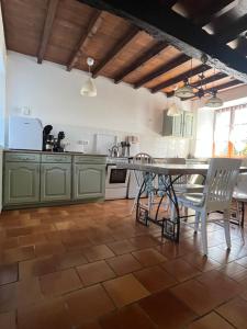 a kitchen with green cabinets and a table and chairs at Gite 2, Domaine Logis Gascogne in Saint-Justin