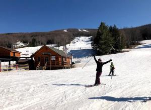 two people on skis in the snow on a ski slope at The Haüs Windham - Spacious Suites, Hot Tub, Mountain Views! in Windham