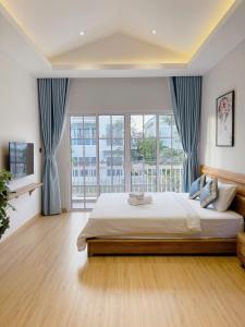 a bedroom with a large bed and a large window at Holiday Villa Novaworld Phan Thiet in Phan Thiet