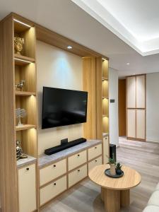a living room with a tv and a coffee table at MODERN 2 BEDROOM LAVAYA OAKWOOD APARTMENT, Nusa Dua in Nusa Dua