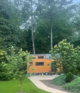 Ein orangefarbener Anhänger steht im Wald. in der Unterkunft Tiny-Haus in Boppard