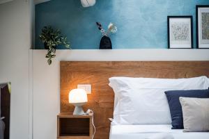 a bedroom with a white bed with a blue wall at Giardini 411 Rooms in Formigine