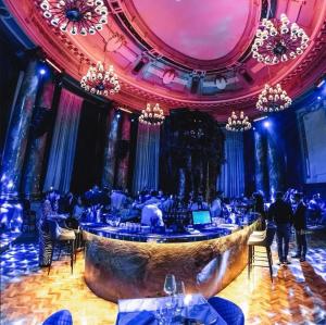a bar in a room with people sitting at tables at NF Palace Old City Bucharest in Bucharest
